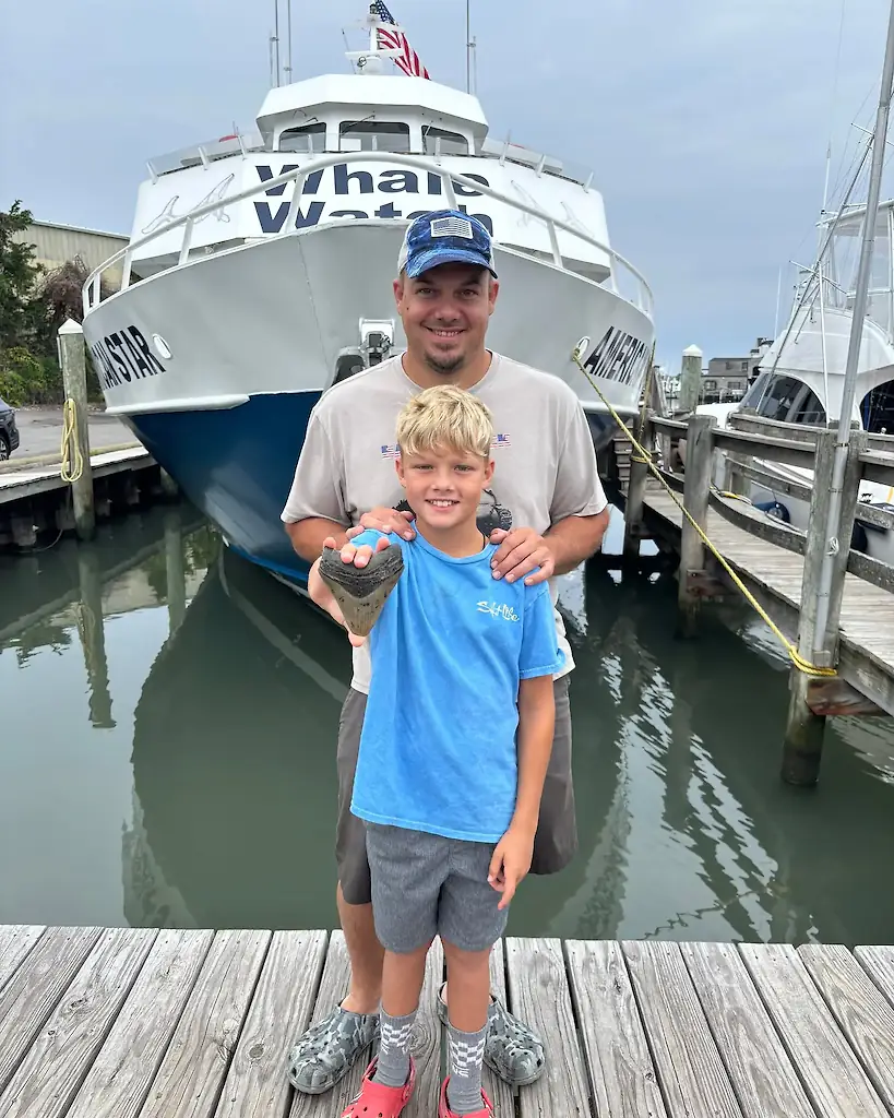 Michael Bowers, 42, and his 11-year-old son Bo found the prehistoric shark tooth at a Sea Isle beach. Credit: Facebook/Cape May Whale Watch and Research Center