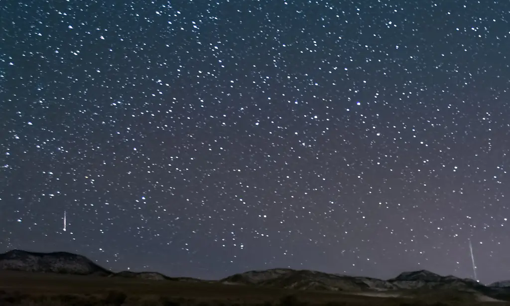 Two people watching a meteor shower. Credit: Harpazo_hope/Getty