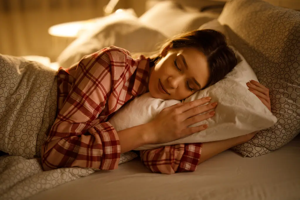 Sleeping on one's side with bent arms curled close to the chest has been dubbed the 'T-Rex position' on social media. Credit: EmirMemedovski / Getty