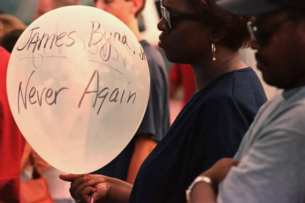 A mourner holding a balloon honoring the victim. Credit: Houston Chronicle/Hearst Newspapers via Getty Images / Getty