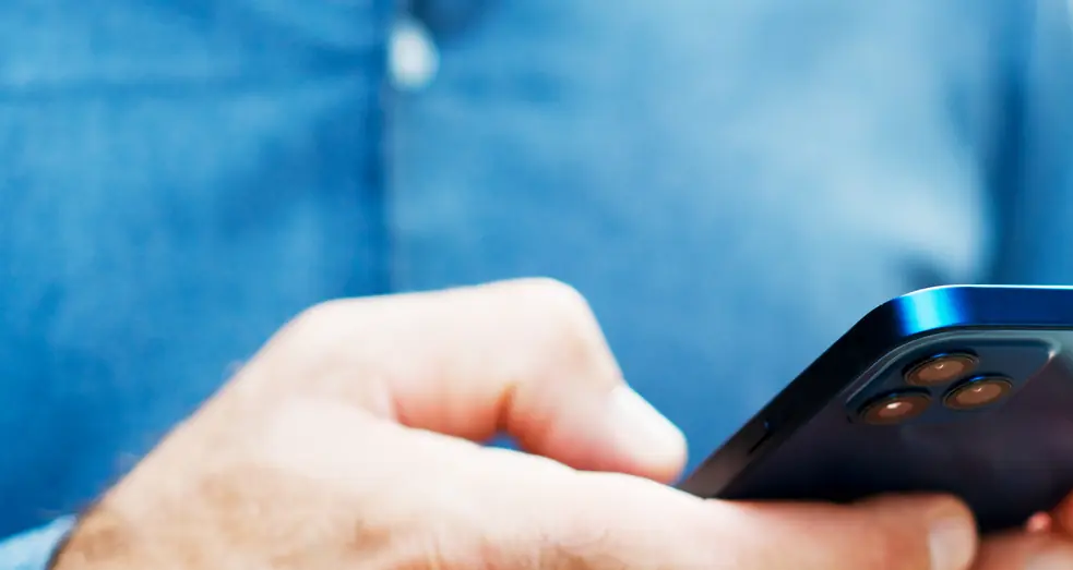 A man texting on a phone.