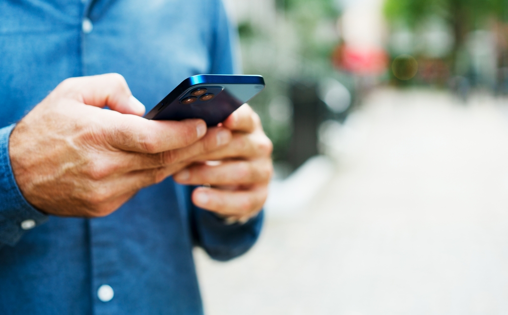 A man texting on a phone.