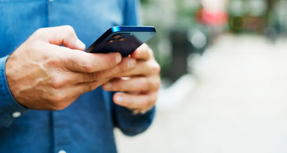 A man texting on a phone.