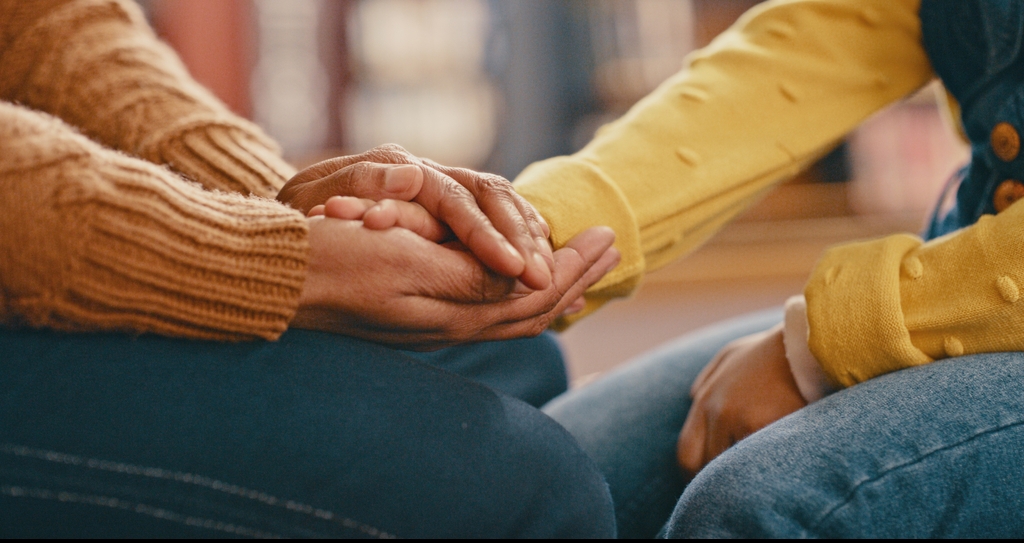 Two women holding hands.