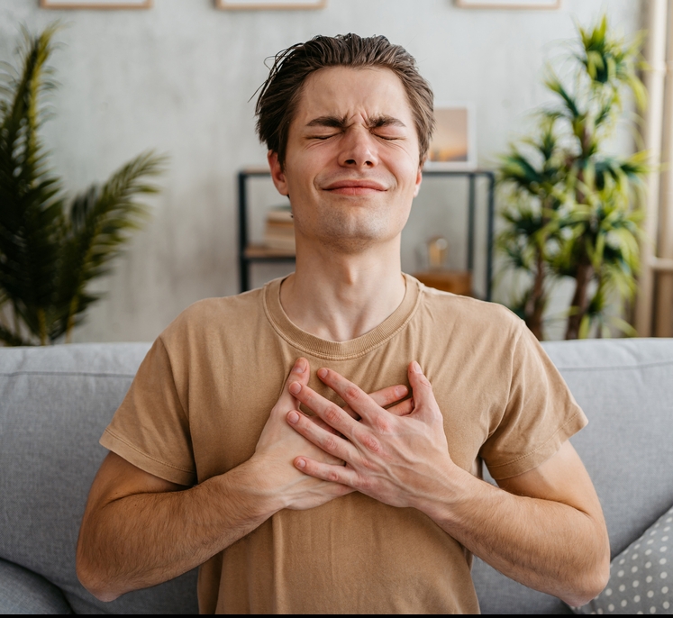 A man clutching his chest. (Heart)