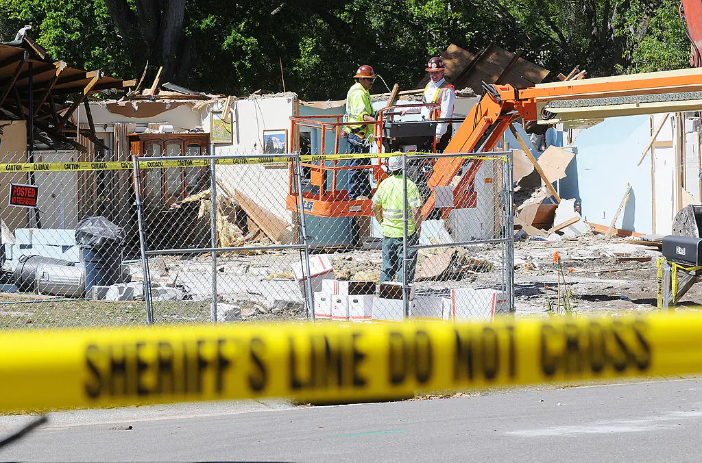 Workers removing belongings from the home where a sinkhole swallowed Jeffrey Bush in Florida, 2013. Demolition crews worked to raze the house, recover possessions, and stabilize the shaky ground. Credit: Gerardo Mora/Getty Images.