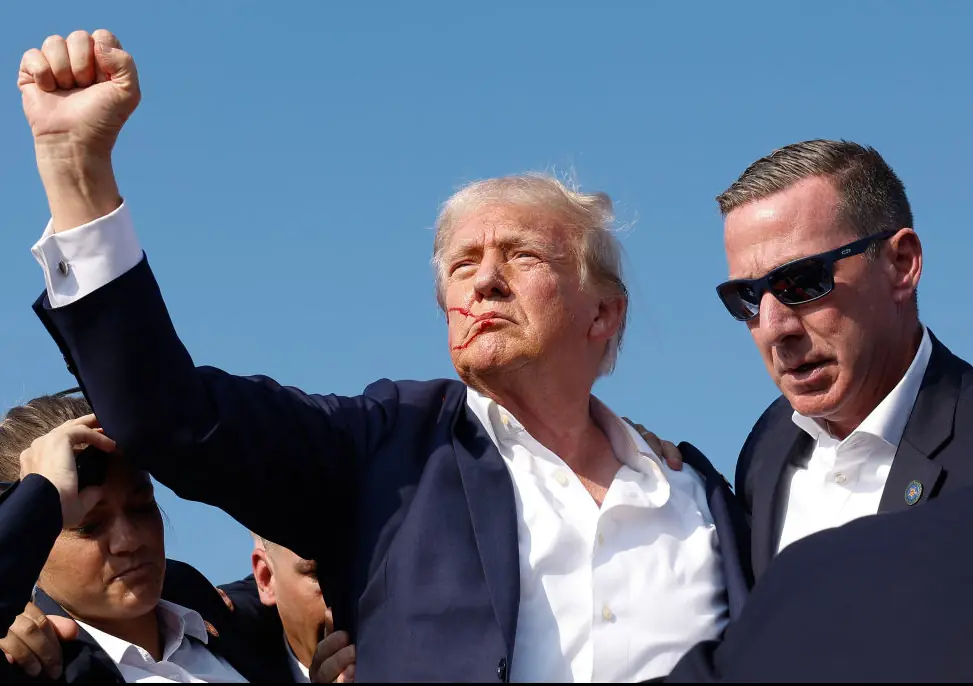 President Donald Trump pumps his fist as he is rushed offstage during the rally in Butler. Credit: Anna Moneymaker/Getty
