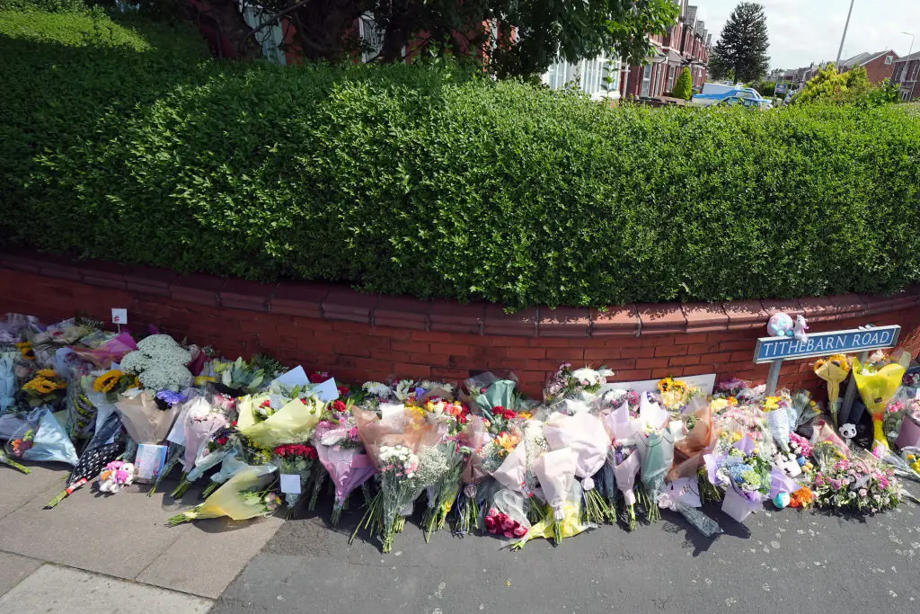 Tributes to the victims are left by well-wishers. Credit: Christopher Furlong/Getty