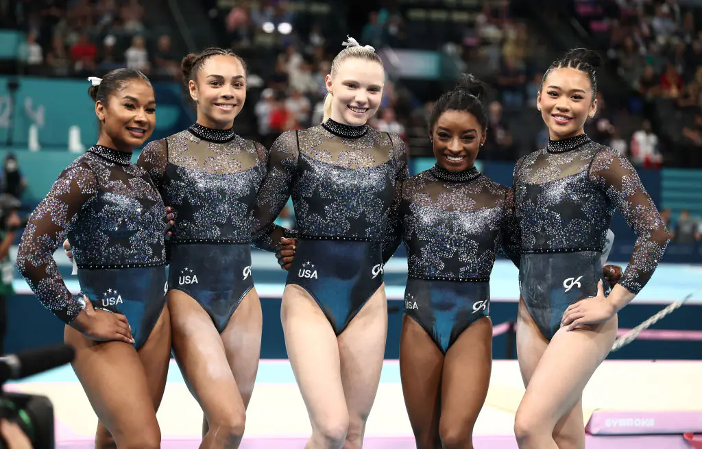 Jordan Chiles, Hezly Rivera, Jade Carey, Simone Biles, and Sunisa Lee of Team United States posing for photos at the Paris games. Credit: Naomi Baker/Getty
