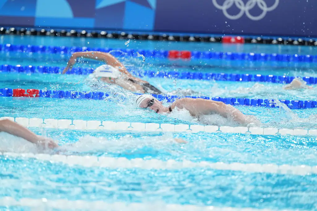 Olympic swimmer collapses after race and is seen being carried away on a stretcher