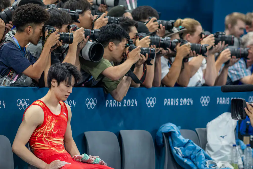 Su Weide sat away from his teammates after he fell twice during his routine. Credit: Tim Clayton - Corbis / Getty