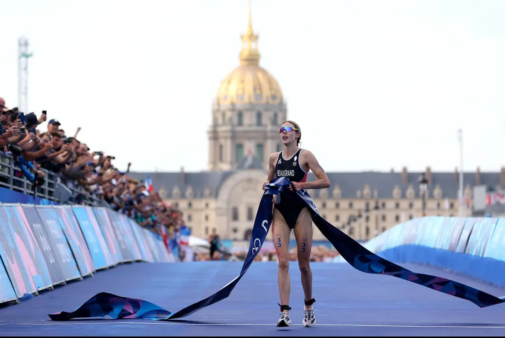 Cassandre Beaugrand of Team France crosses the finish tape to win the gold medal after competing in Women's Individual Triathlon. Credit: Michael Steele/Getty