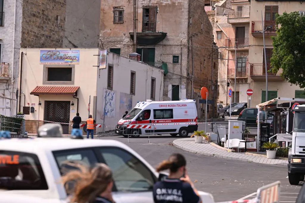 An ambulance is parked near the harbor where a search continues for missing passengers after a yacht capsized. Credit: Vincenzo Pepe/Getty 