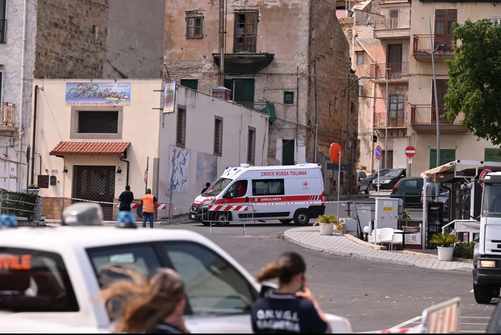 An ambulance is parked near the harbor where a search continues for missing passengers after a yacht capsized. Credit: Vincenzo Pepe/Getty 