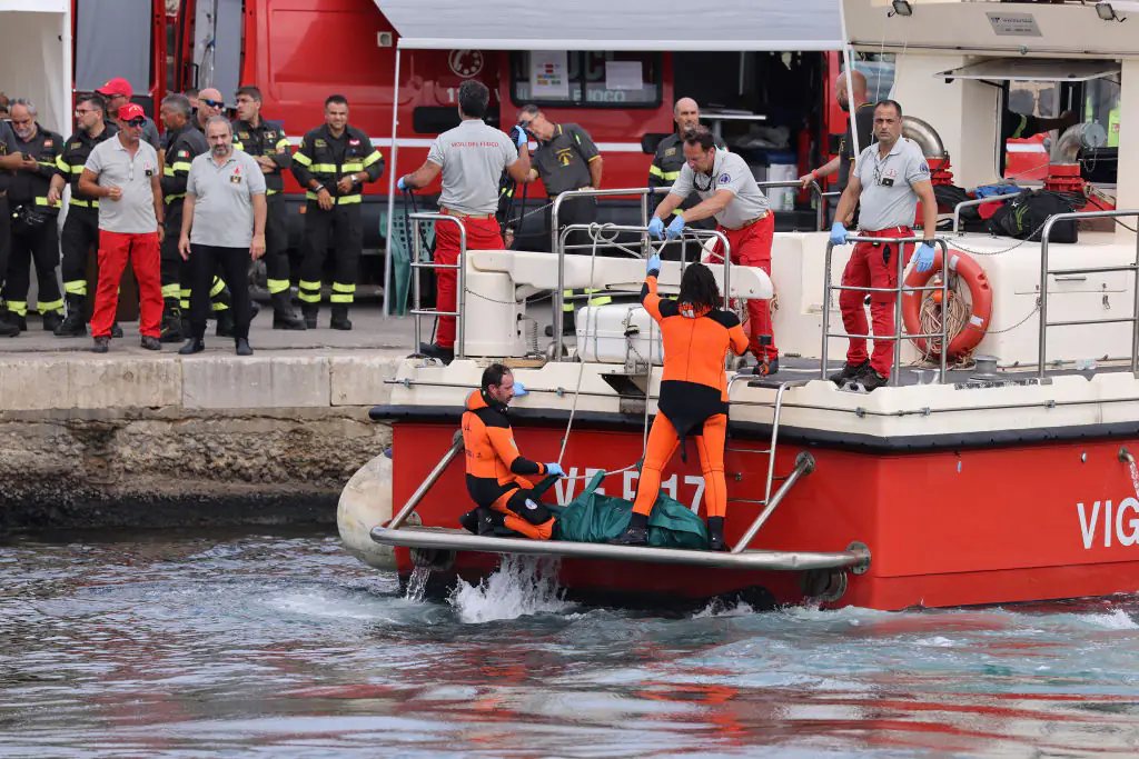 Firefighter teams, Vigili del Fuoco, arrive in Porticello harbor with a recovered body after the British-flagged luxury yacht Bayesian sank off the Italian coast. Credit: Alberto Lo Bianco/Anadolu/Getty