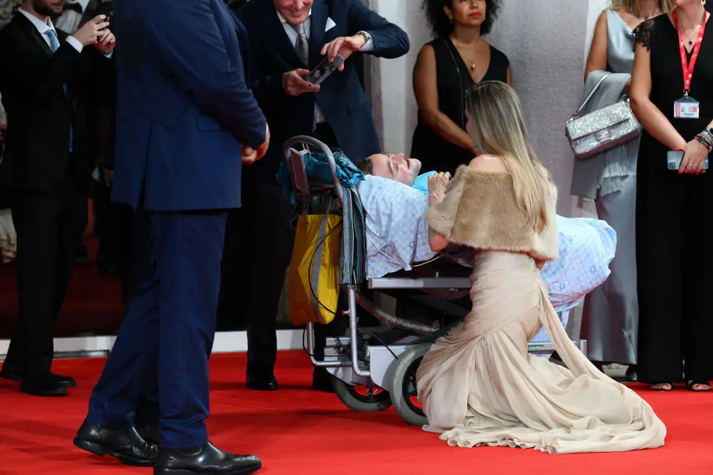 Jolie kneeling beside a fan at the 81 Venice International Film Festival. Credit: Marilla Sicilia/Archivio Marilla Sicilia/Mondadori Portfolio/Getty