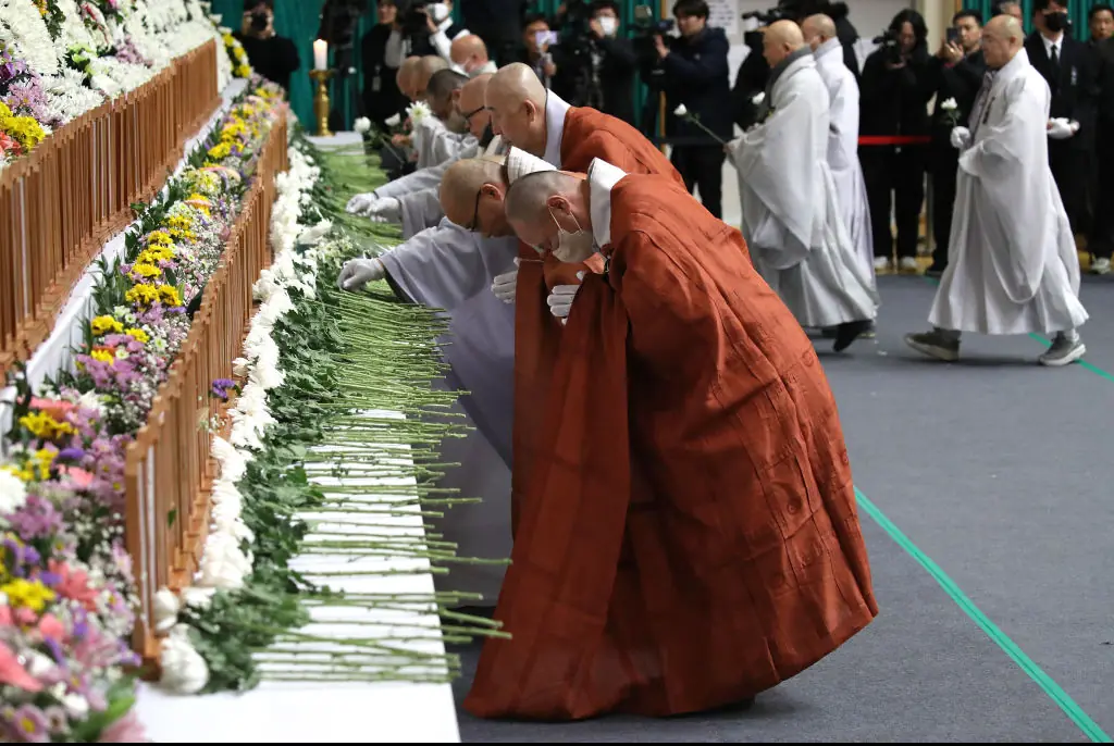 South Korean monks pay tribute at a group memorial altar for victims of Flight 7C2216. Credit: Chung Sung-Jun/Getty