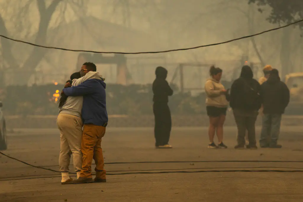 Residents embraced each other after the fire destroyed their homes. Credit: David McNew / Getty