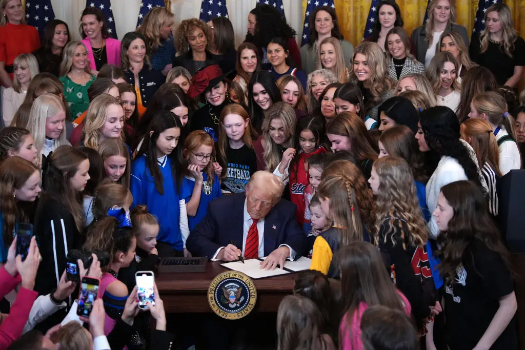 Trump joined by women athletes signs the “No Men in Women’s Sports” executive order in the East Room at the White House on February 5, 2025. Credit:	Andrew Harnik / Getty