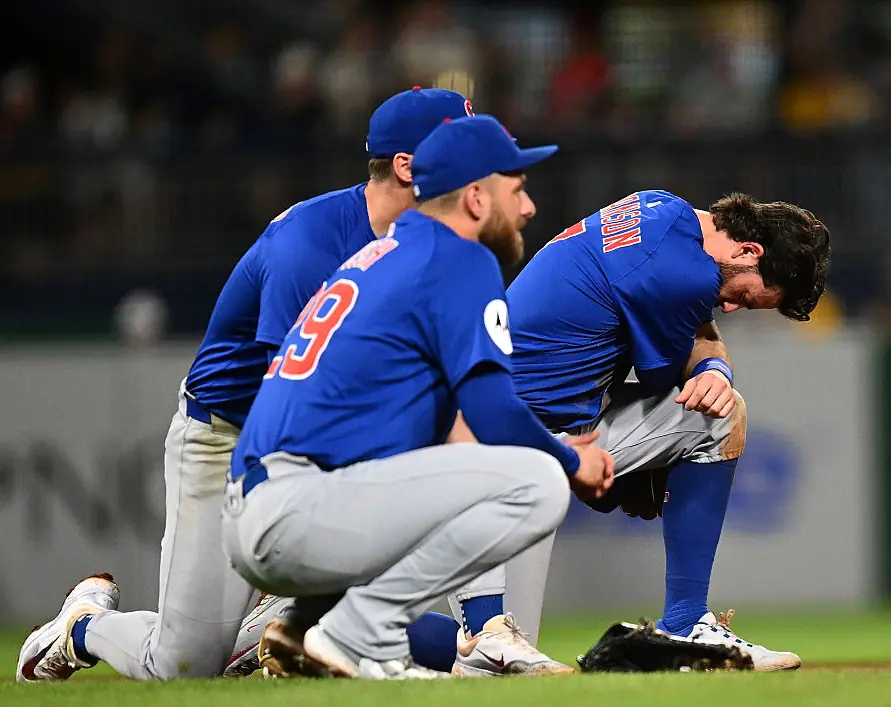 Cubs players watch on as medics attend to Markwood. Credit: Joe Sargent/Getty Images