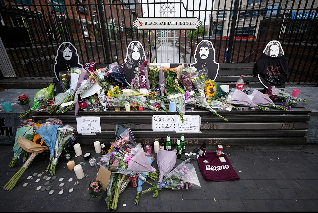 Flowers, candles and messages in memory of Ozzy Osbourne are left on the Black Sabbath Bridge bench on Broad Street. Credit: Christopher Furlong / Getty
