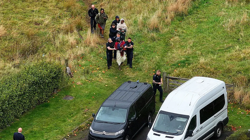 Members of the "Kingdom of Kubala," led away by Scottish immigration enforcement. Credit: Jeff J Mitchell / Getty Images.