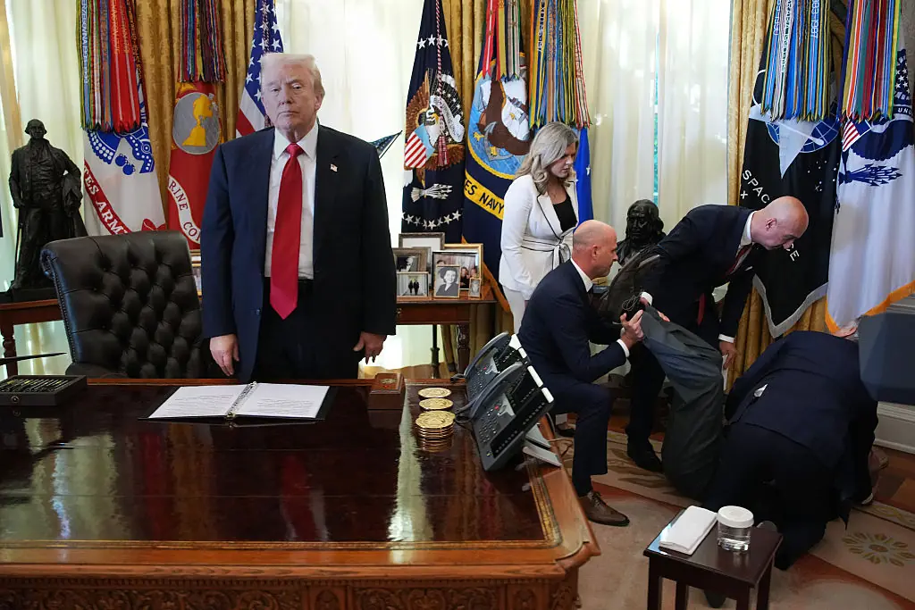 President Donald Trump stands by as attendees help a guest after he collapsed during an event on lowering drug prices. Credit: Andrew Harnik / Getty
