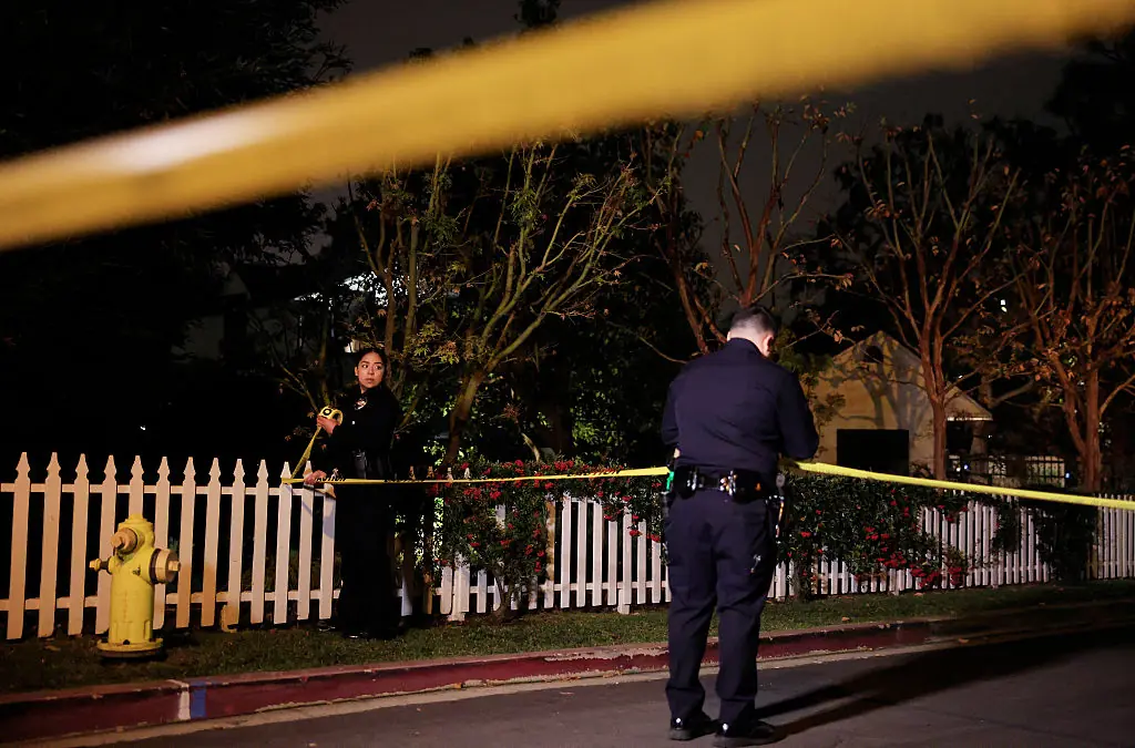 LAPD officers put up police tape as the police investigate two people found dead in Rob Reiner's home on December 14. Credit: Mario Tama / Getty