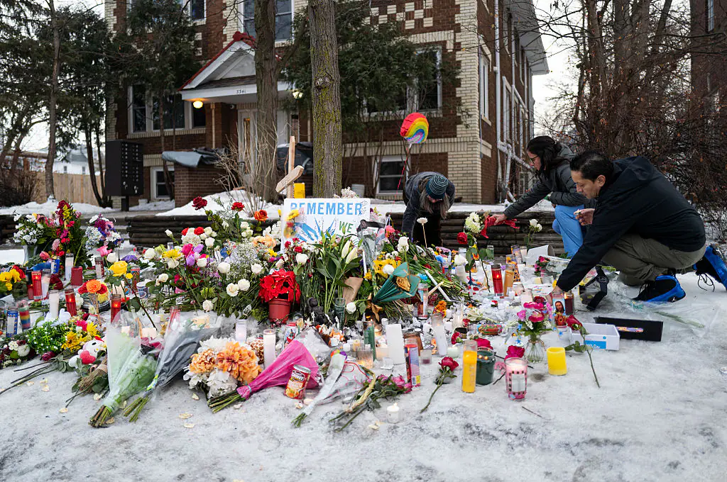 People tend to a memorial for Renee Nicole Good near the site of her shooting. Credit: Stephen Maturen / Getty