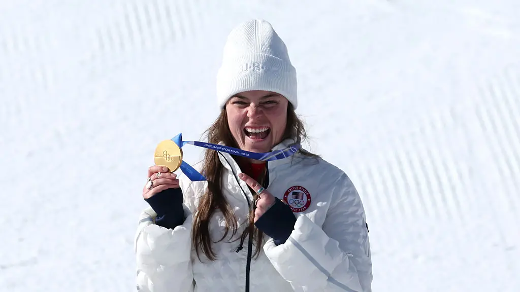 CORTINA D'AMPEZZO, ITALY - FEBRUARY 08: Gold medalist Breezy Johnson of Team United States celebrates on the podium during the medal ceremony for the Women's Downhill on day two of the Milano Cortina 2026 Winter Olympics at Tofane Alpine Skiing Centre on February 08, 2026 in Cortina d'Ampezzo, Italy. (Photo by Al Bello/Getty Images)