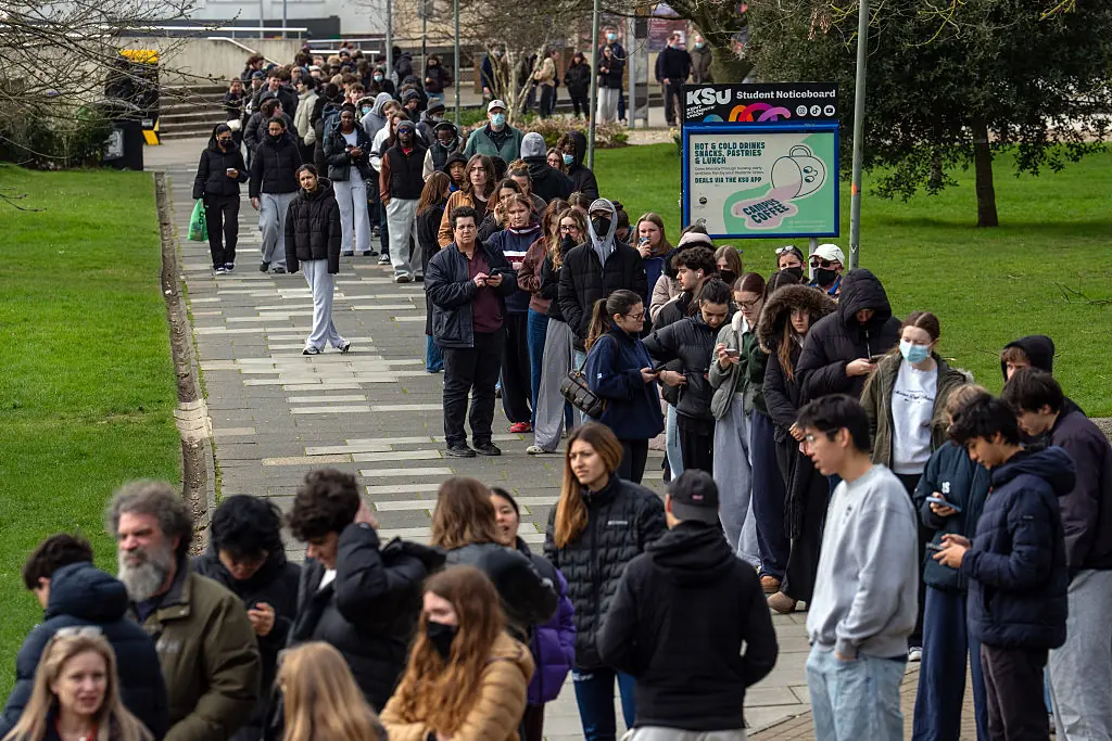Staff and students, some wearing face masks, queue to receive antibiotics at the University of Kent in Canterbury after an outbreak of meningitis caused the deaths of two people. Credit:	Carl Court / Getty