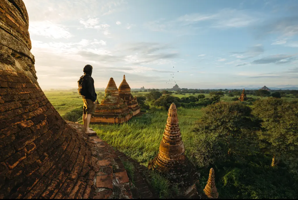 A tourist standing on beautiful pagoda during a stunning sunrise in Bagan, Myanmar. Credit: Sam Spicer/Getty