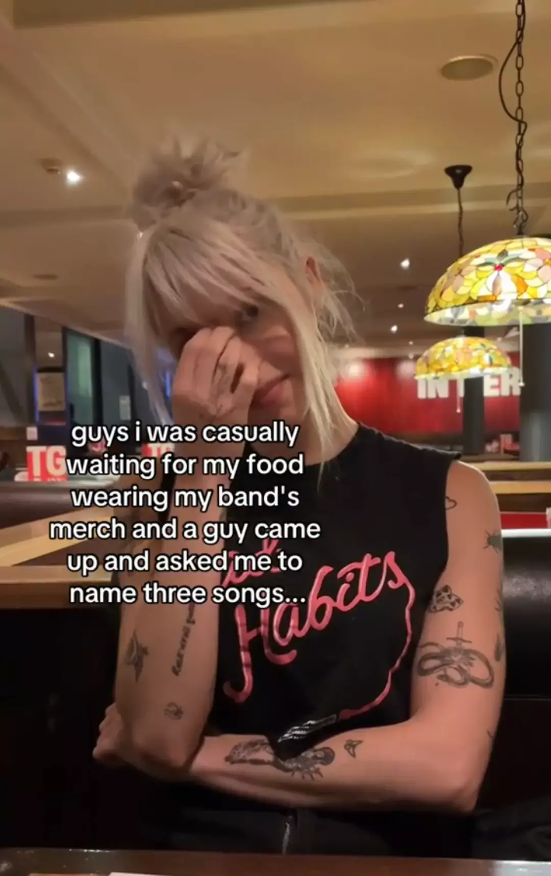 Man awkwardly mocks woman wearing band t-shirt without having a clue who she is