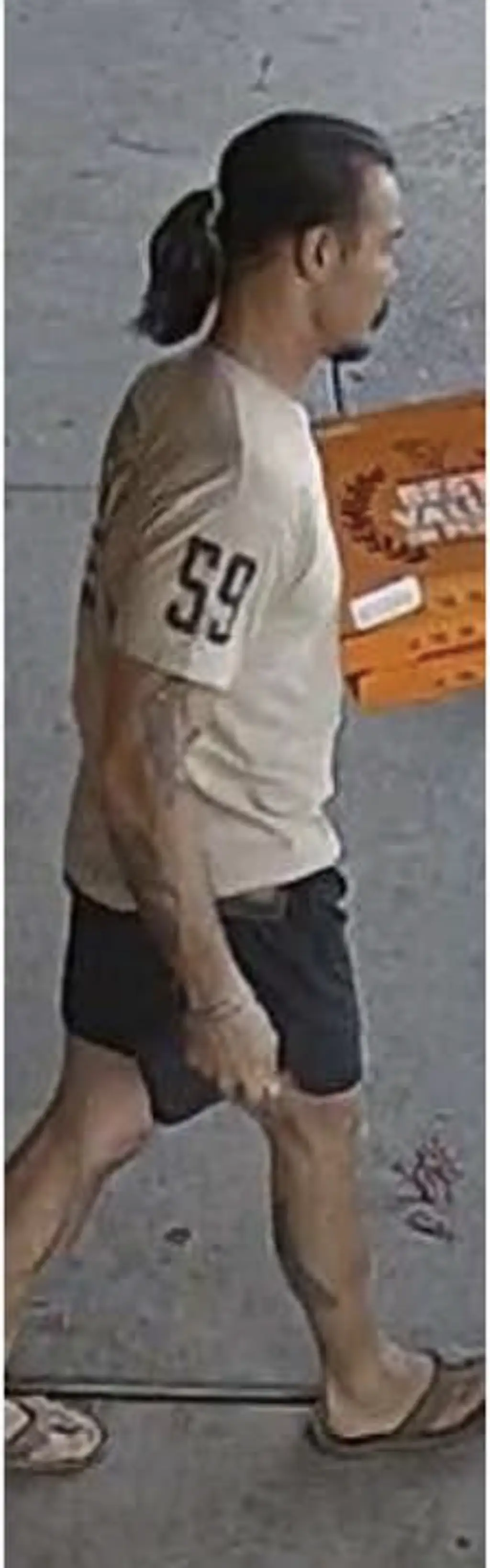 New images show Travis Decker wearing a tan shirt with the number 59 on the sleeve, dark shorts, flip flops with his hair tied back, carrying pizza boxes. Credit: Chelan County Sheriff's Office 
