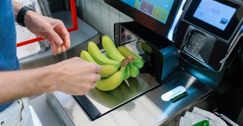 Man unwraps his bananas before weighing them at checkout to save money