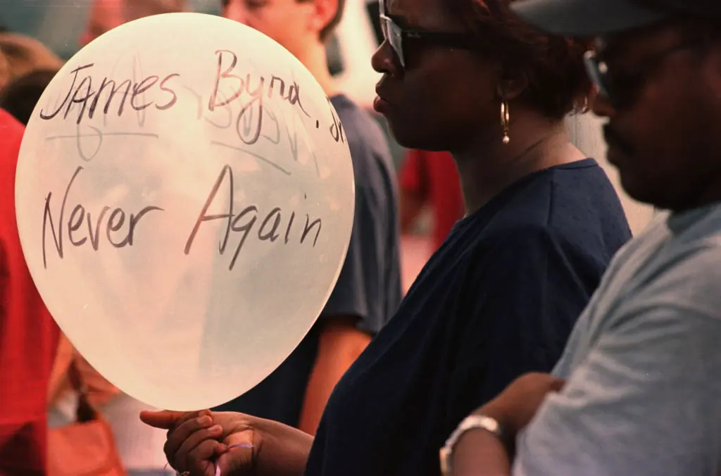 a balloon reading 'James Byrd Jr. Never Again' as she prays during the Prayer Vigil Monday evening at the Jasper Co. Courthouse.Credit: Houston Chronicle/Hearst Newspapers via Getty Images / Getty