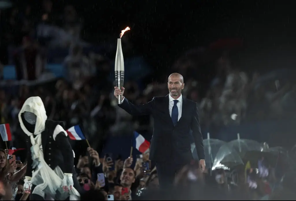 French former football player Zinedine Zidane carries the Olympic torch at the Trocadero during the opening ceremony of the Paris 2024 Olympics. Credit: Mustafa Ciftci/Anadolu/Getty 