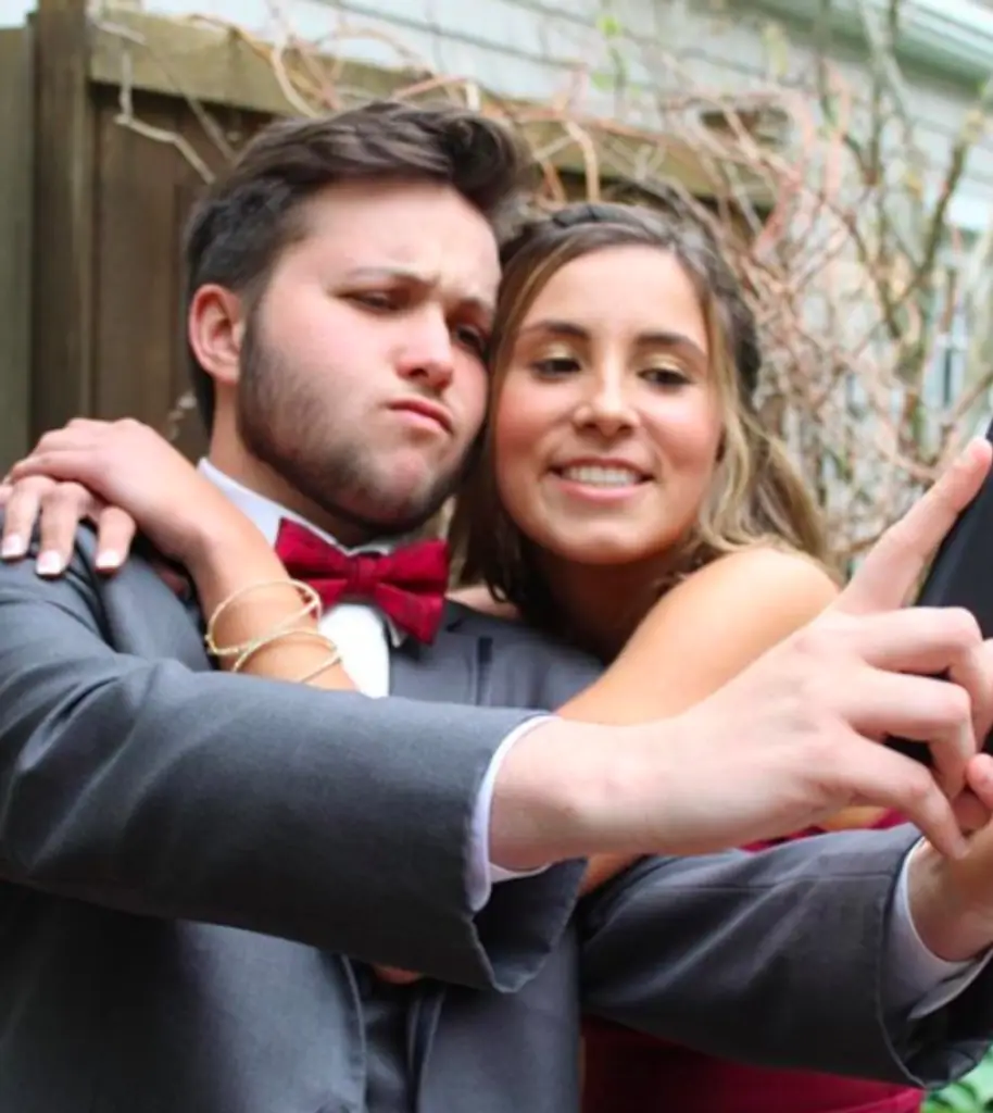 Two teenagers taking a selfie at prom. 