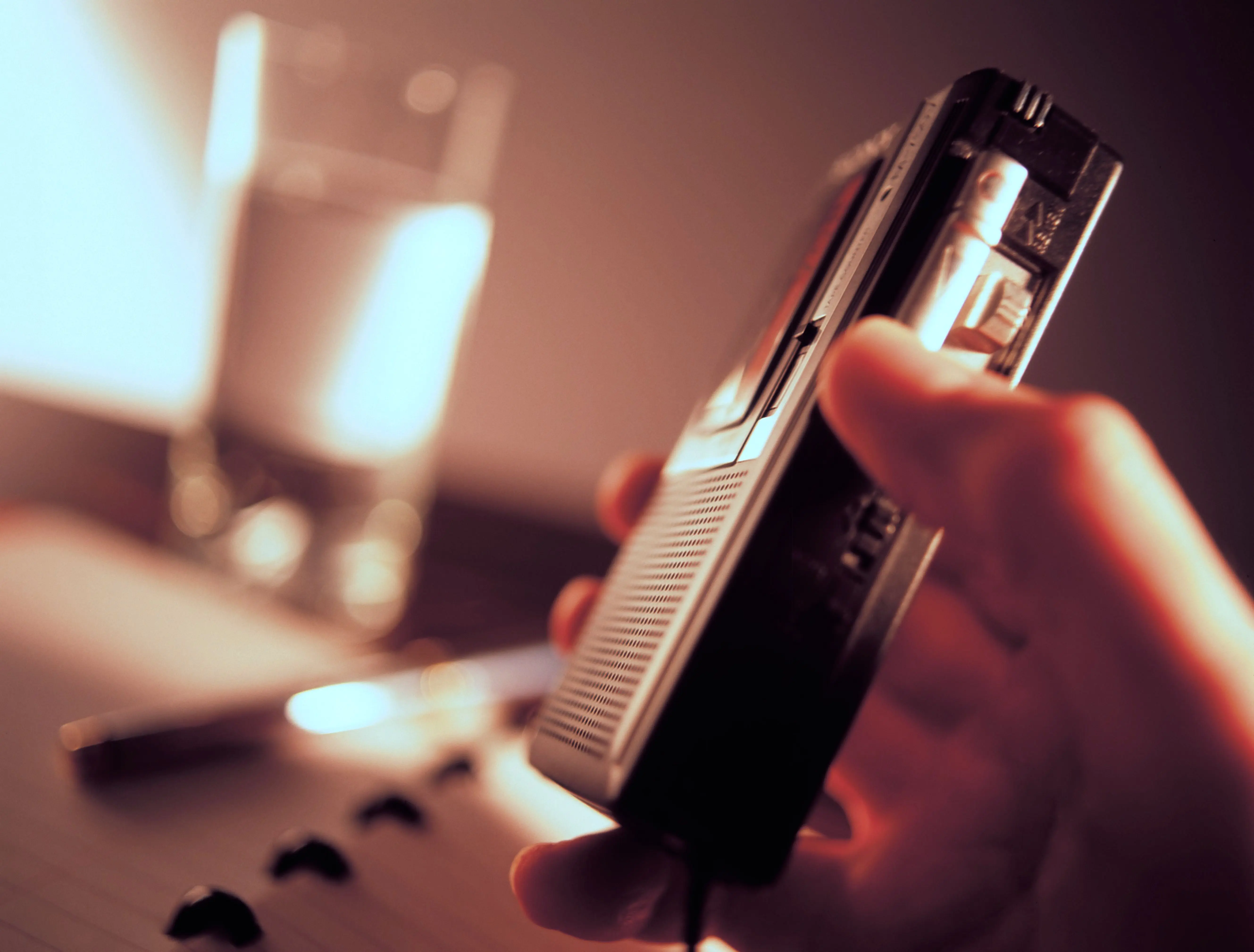 A man holds a tape recorder in an interview room