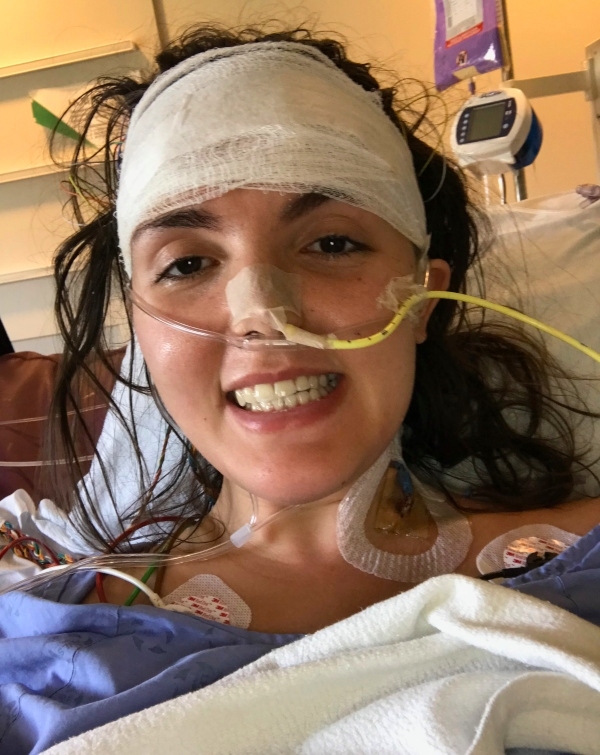 A woman smiling in a hospital bed.