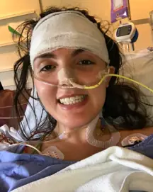 A woman smiling in a hospital bed. 