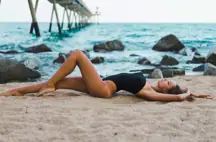 A woman lying on a beach.