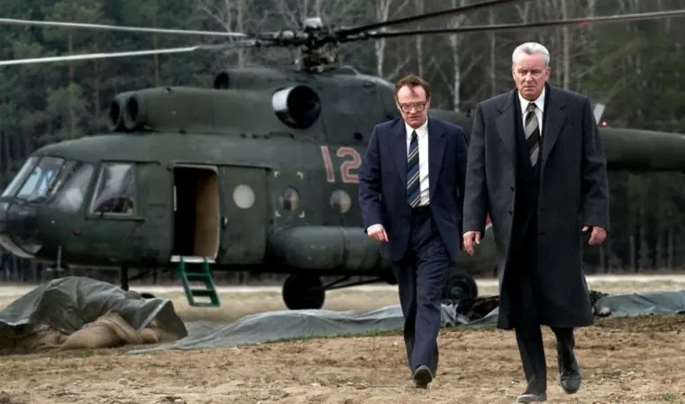Two men walking away from a helicopter. 