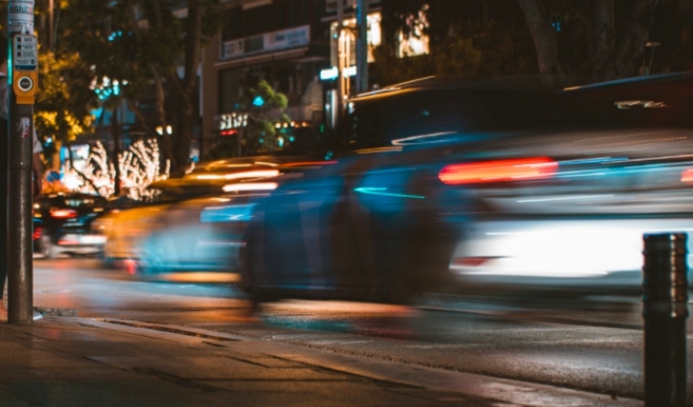 Cars speeding by at night.