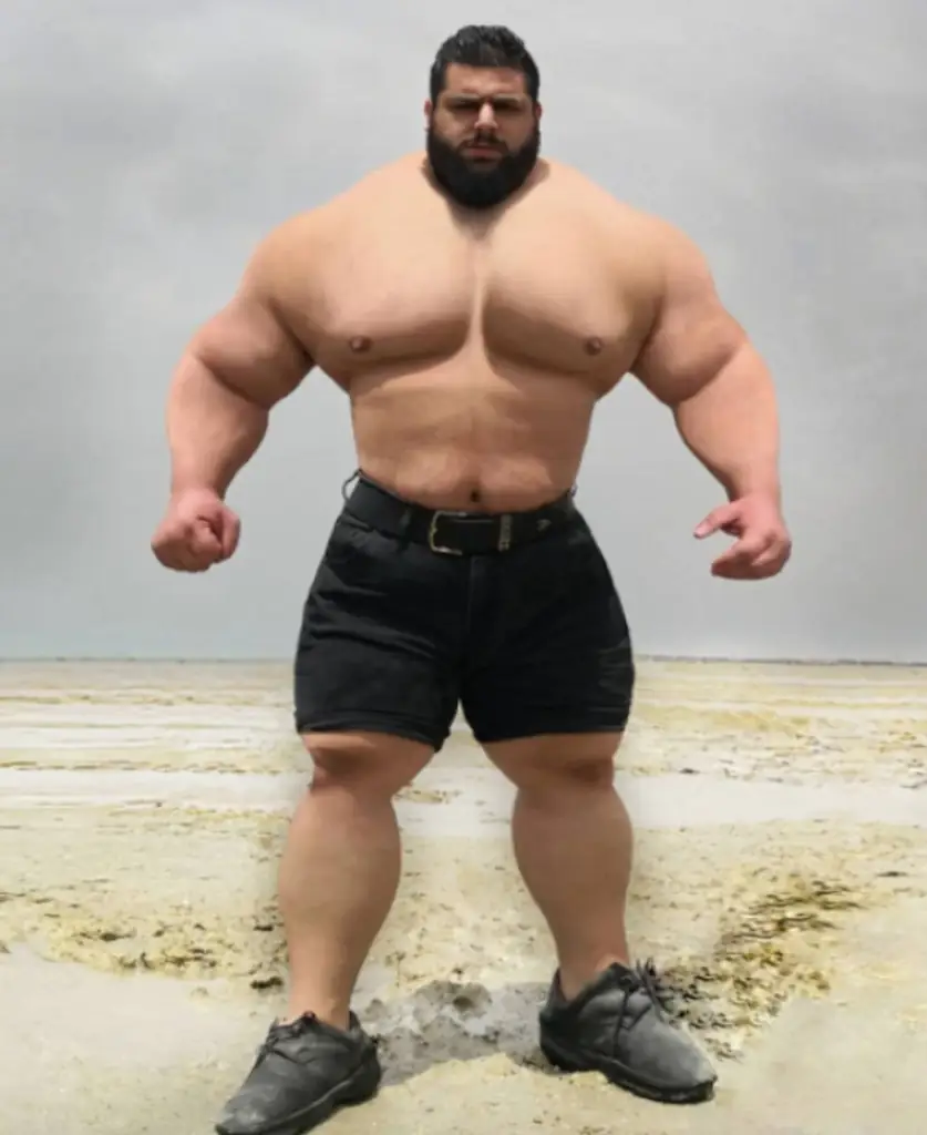 The Iranian Hulk standing on a sandy beach. 