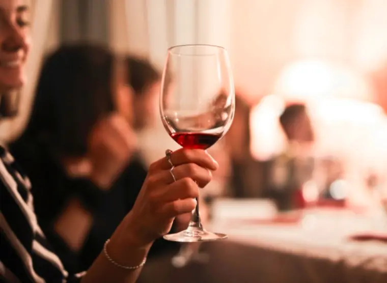 A woman holding a glass of wine. 