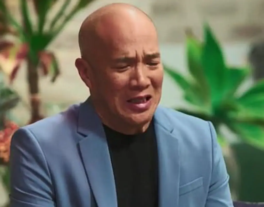 A man reacting to a woman smearing period blood on her face. 