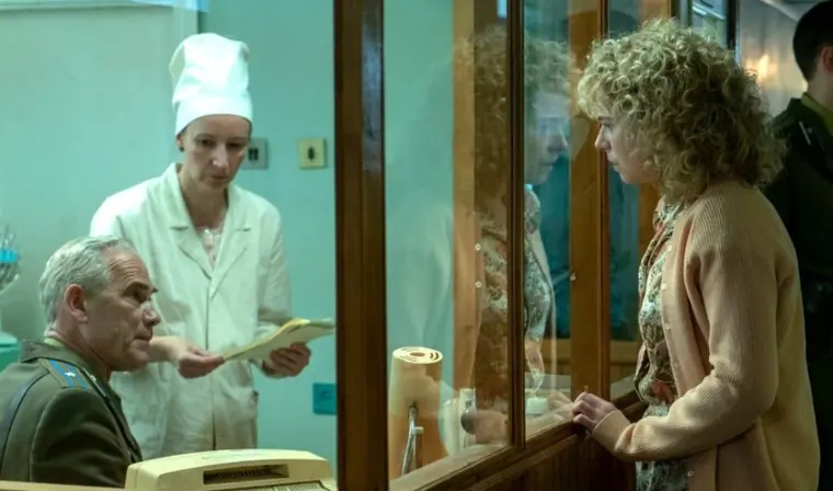 A woman looking through a glass barrier.