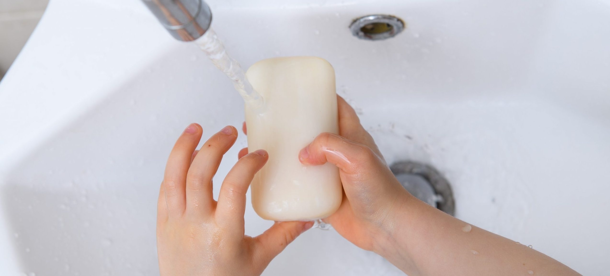 A child washing their hands. 