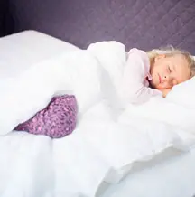 A child sleeping in a holey quilt.